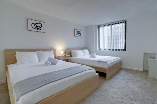 1 Schlafzimmer mit 2 Betten und einem Fenster in der Unterkunft Spacious & Comfortable Condo at Crystal City in Arlington