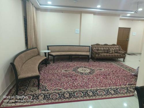 a living room with two chairs and a rug at Sakez Homestays in Hyderabad