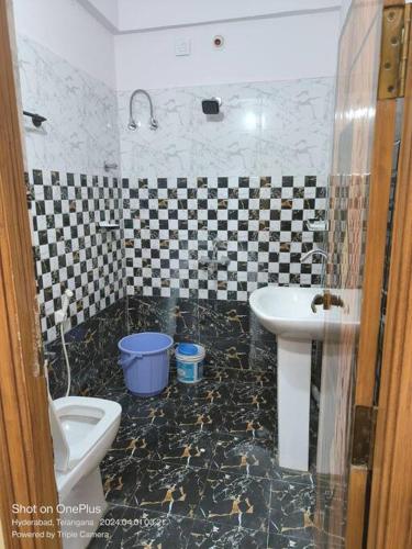 a bathroom with a sink and a toilet at Sakez Homestays in Hyderabad