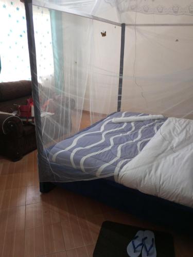 a bed with a canopy in a room at Annex in Kakamega