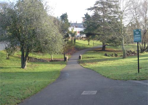 a winding path in a park with trees and grass at Hideaway in Torquay