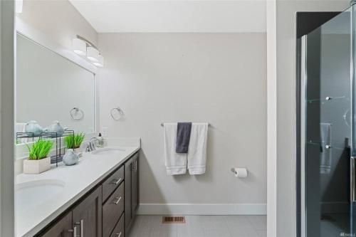 a white bathroom with a sink and a shower at New Town House - Heart of Wenatchee in Wenatchee