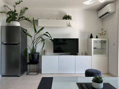 Il comprend un salon doté de placards blancs et d'une télévision à écran plat. dans l'établissement Studio 3 étoiles vue mer - terrasse - plage, à Vallauris