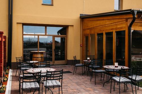 a patio with tables and chairs in front of a building at Pansion Mihića dvori in Babina Greda