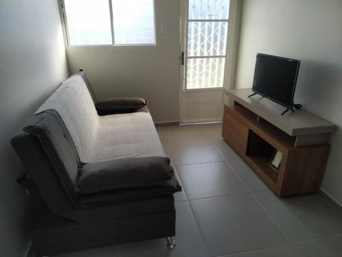 a living room with a chair and a television at My House Hospedagem in Santo Ângelo