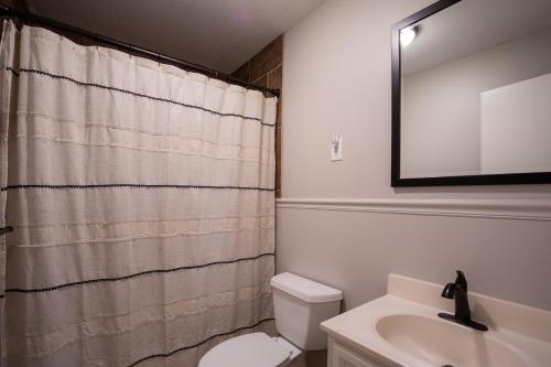a bathroom with a white toilet and a sink at Oxford Hillside Hideaway in Oxford