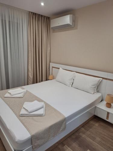a bedroom with a bed with two white towels on it at Sandanski park view in Sandanski