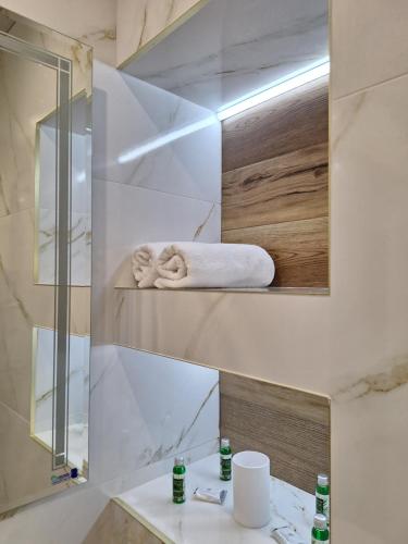 a bathroom with a sink and a mirror and towels at Sandanski park view in Sandanski