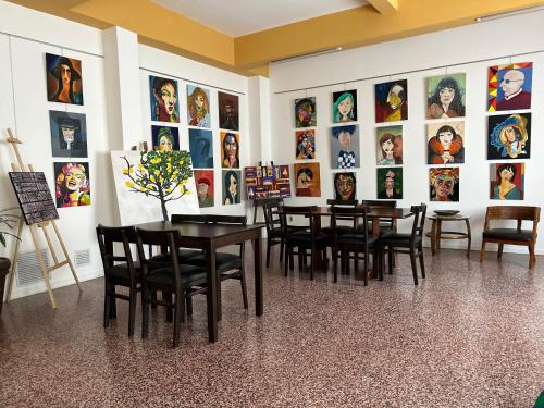 a dining room with tables and chairs and pictures on the wall at Hotel Tamariz in Piriápolis
