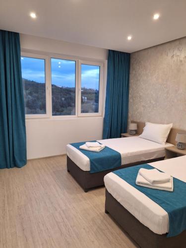 Habitación de hotel con 2 camas y 2 ventanas en Sandanski park view, en Sandanski