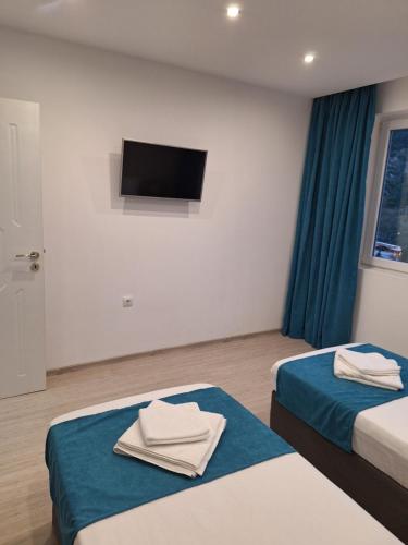 a hotel room with two beds and a flat screen tv at Sandanski park view in Sandanski