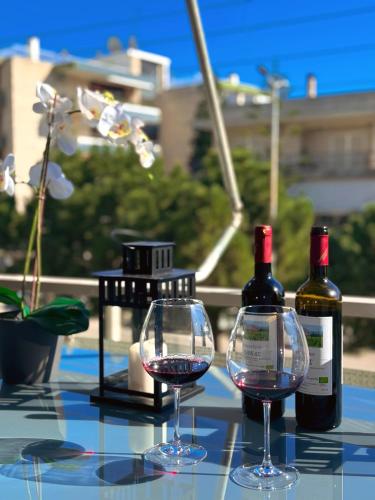 dos botellas de vino y dos copas en una mesa en John‘s house, en Atenas