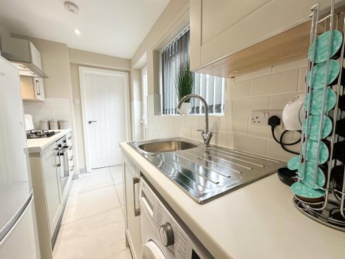 a kitchen with a sink and a counter at Brand New Modern Boutique Home in Liverpool