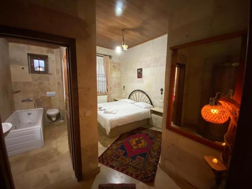 a bedroom with a bed and a tub and a sink at Arnovalley Hotel in Urgup
