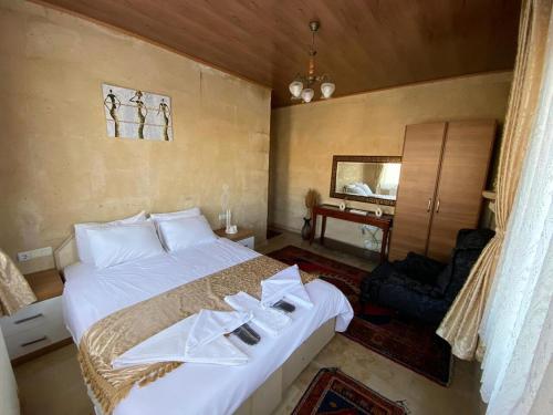Un dormitorio con una cama blanca con toallas. en Arnovalley Hotel en Urgup