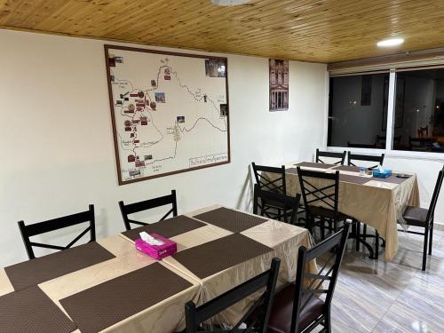 a dining room with two tables and a map on the wall at Amro Petra Apartment in Wadi Musa