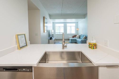 a kitchen with a sink and a living room at Class & Space Uptown in Charlotte
