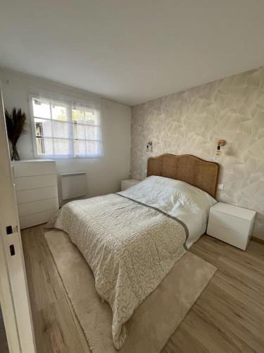Un dormitorio con una cama grande y una ventana en Petite maison cosy en campagne, en Neuilly