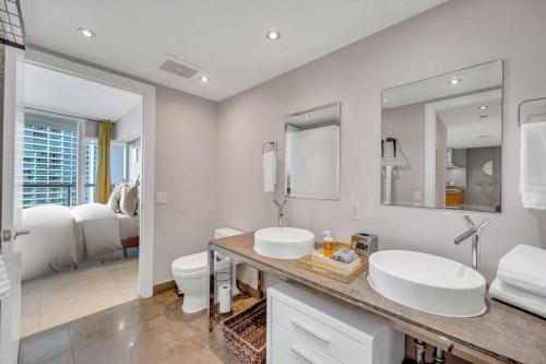 a white bathroom with two sinks and a toilet at Icon 39th Floor 1 Bedroom apartment- Bay & City View- FREE SPA in Miami