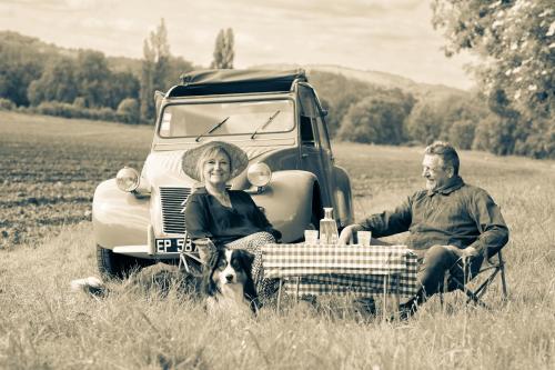 a man and a woman sitting in front of an old truck at Le Moulin du Porteil in Campagne