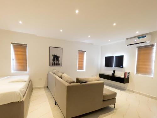 a living room with a couch and a tv at luxe apartments in Lagos
