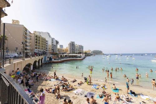 a group of people on a beach in the water at Valletta View Apartment - Wish Malta in Sliema