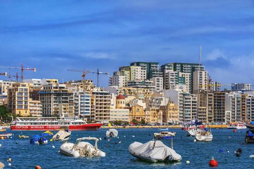 a group of boats in a body of water with buildings at Valletta View Apartment - Wish Malta in Sliema