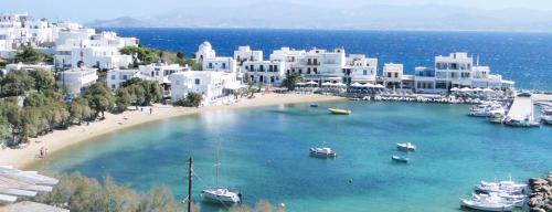 a beach with boats in the water and buildings at Dolce Vita Waterfront Villa, Logaras, Paros in Kampos Paros