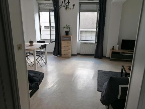 a living room with a table and a dining room at Appartement-Vierzon-centre in Vierzon