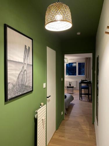a hallway with green walls and a ceiling with a lamp at Le Wimbledon in Chalon-sur-Saône