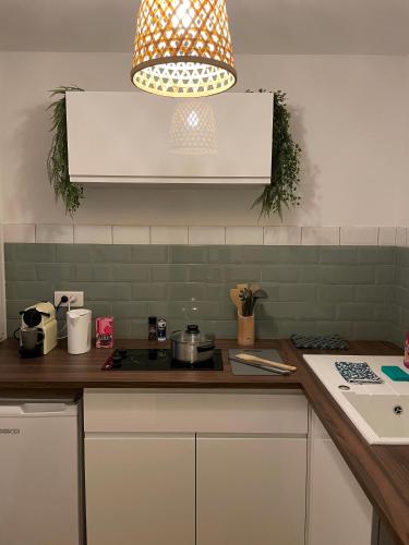 a kitchen with a counter with a stove and a light at Le Wimbledon in Chalon-sur-Saône
