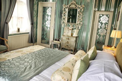 a bedroom with a bed and a dresser and a mirror at The Hotel Commodore in Llandrindod Wells