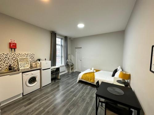 a bedroom with a bed and a desk and a washing machine at Stay Inns in Birmingham
