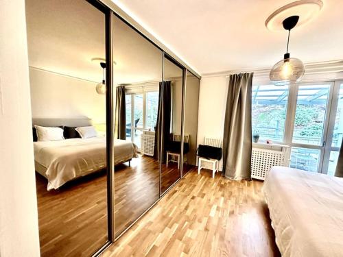 een slaapkamer met 2 bedden en een grote spiegel bij The Majestic Residence -Liseberg - Svenska mässan in Göteborg