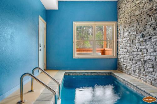 a swimming pool in a blue room with a window at Rustic Mountain Retreat by Ghosal Luxury Lodging in Pigeon Forge