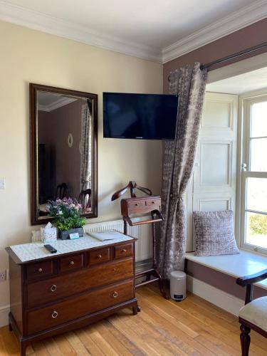 a living room with a dresser and a mirror at Bealkelly Country House in Killaloe