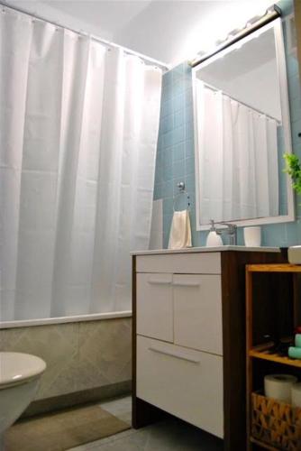 a bathroom with a white shower curtain and a sink at Habitación céntrica in Valencia