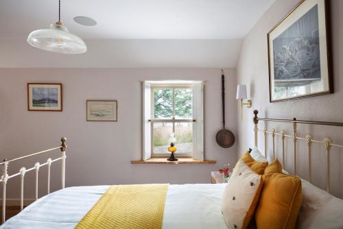 1 dormitorio con cama y ventana en Secluded Thatched Cottage, near beaches & hill walking, en Rashenny
