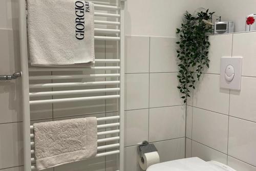 ein weißes Bad mit einem WC und einer Pflanze in der Unterkunft Private Rooms in Hannover