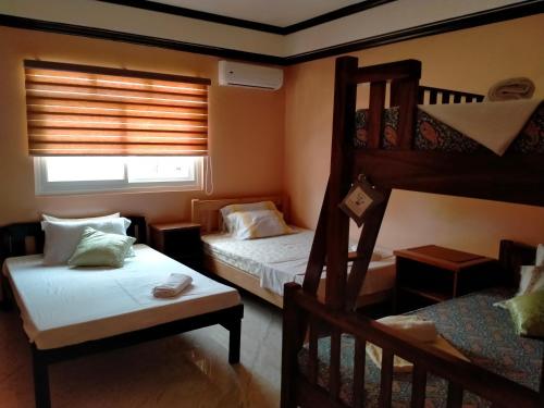 1 Schlafzimmer mit 2 Etagenbetten und einem Fenster in der Unterkunft Cesar Villa sea side in Tagudin