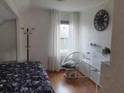 a bedroom with a bed and a desk and a clock at Bergsgatan 5 Arjeplog in Arjeplog