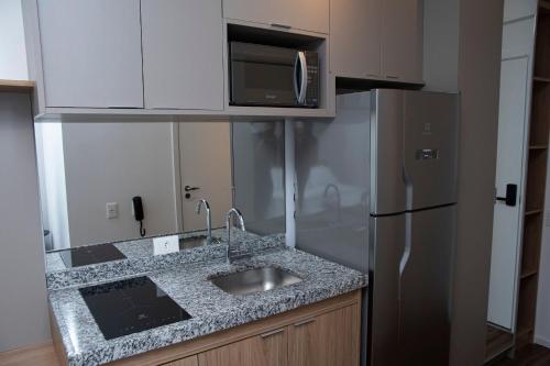 a kitchen with a sink and a refrigerator at ST Studios Vila Mariana by Housi in Sao Paulo