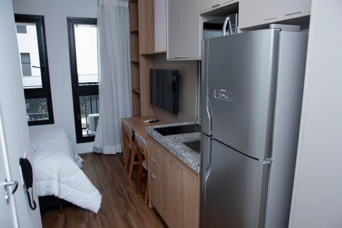 a kitchen with a stainless steel refrigerator and a counter at ST Studios Vila Mariana by Housi in Sao Paulo