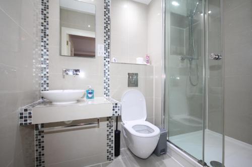 a bathroom with a toilet and a sink and a shower at Harrow On The Hill Place in London