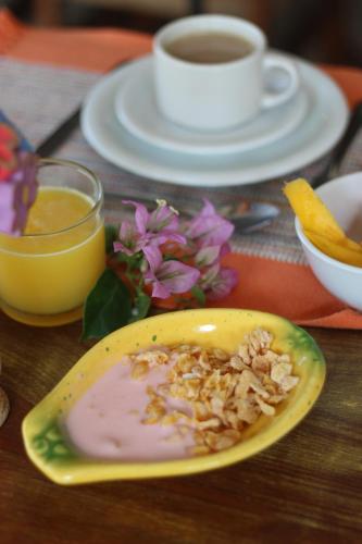 a table with a plate of food and a cup of coffee at Pousada Alforria in Búzios