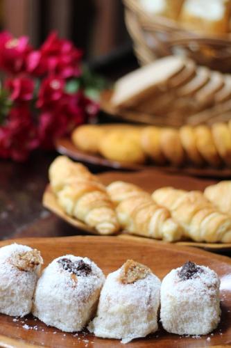 a group of pastries on a table with other bread at Pousada Alforria in Búzios
