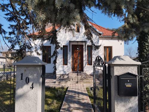 a white house with a gate in front of it at Bela Vila in Banja Koviljača