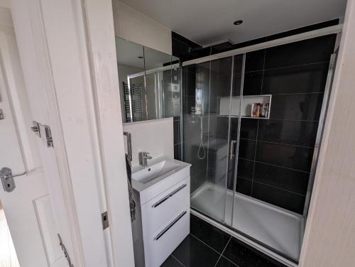 a bathroom with a shower and a sink and a shower at Luxury Hotel Rooms in Palmers Green