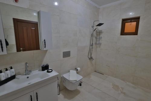 a white bathroom with a toilet and a sink at Yellow Stone House in Goreme