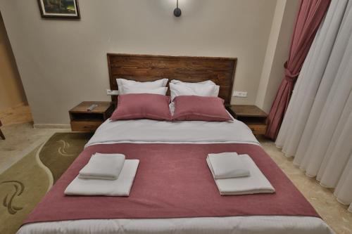 a bedroom with a large bed with red and white pillows at Yellow Stone House in Goreme